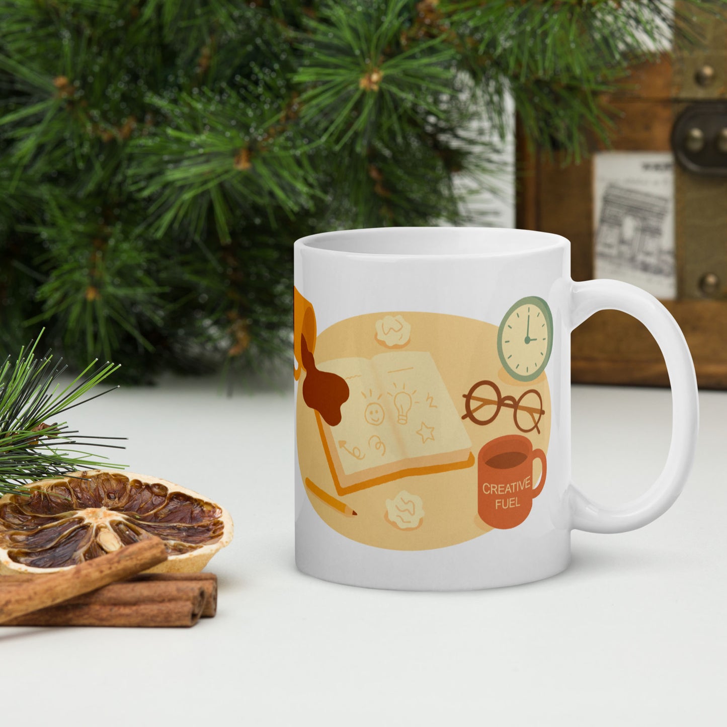 White ceramic mug featuring a playful late-night creativity illustration with coffee, sketches, and a clock, shown in a cozy holiday-style mockup with pine branches, dried citrus, and cinnamon for wid Designs.