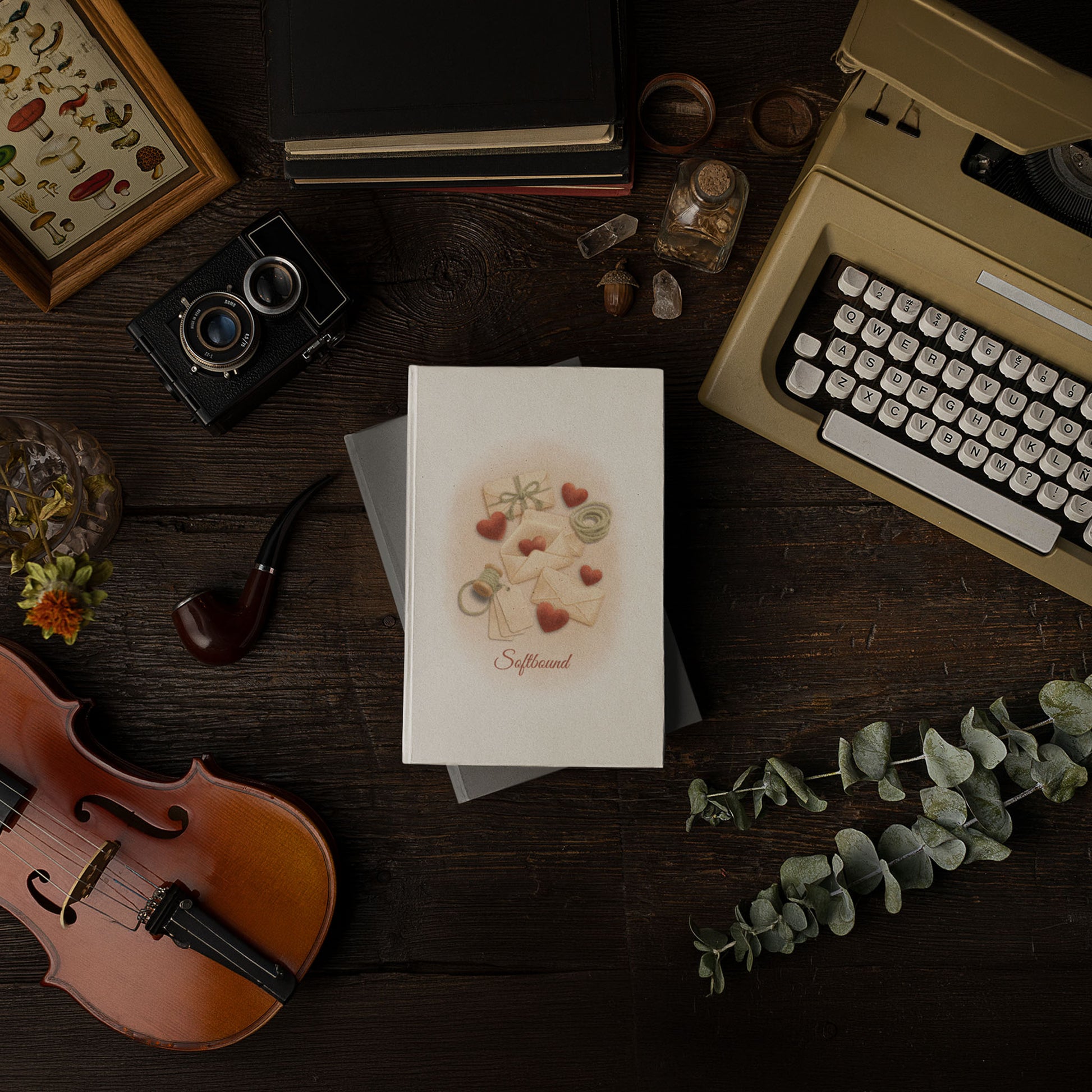 Matte hardcover Softbound journal placed on an old wooden desk surrounded by vintage objects, including a typewriter, camera, violin, and books.