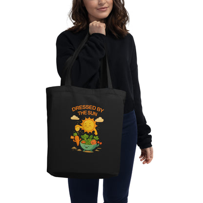 Model holding wid Designs eco tote bag in black, front view.