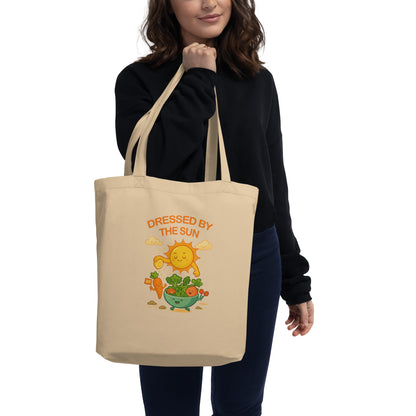Model holding wid Designs eco tote bag in oyster color, front view.